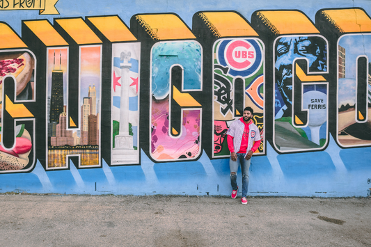 a mural that says chicago with a man standing in front of it