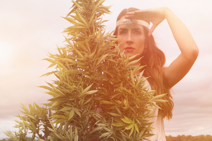 a woman next to a cannabis plant
