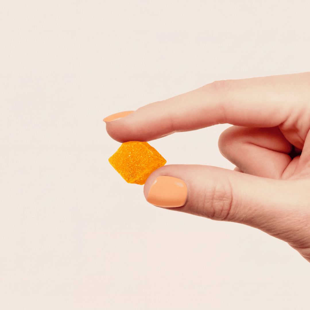 hand holding an orange gummy