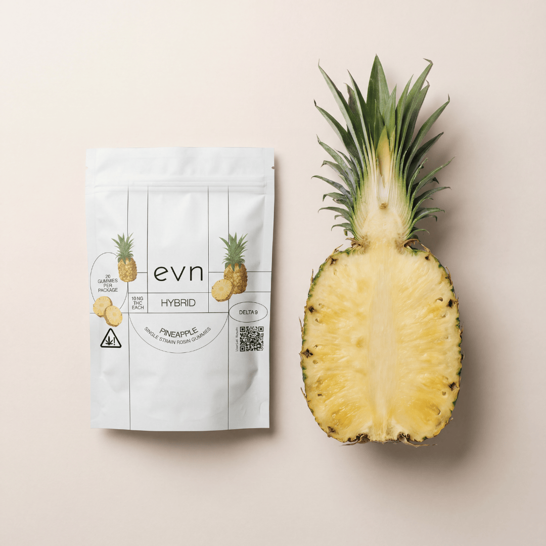 a cut open pineapple with a gummy pouch next to it