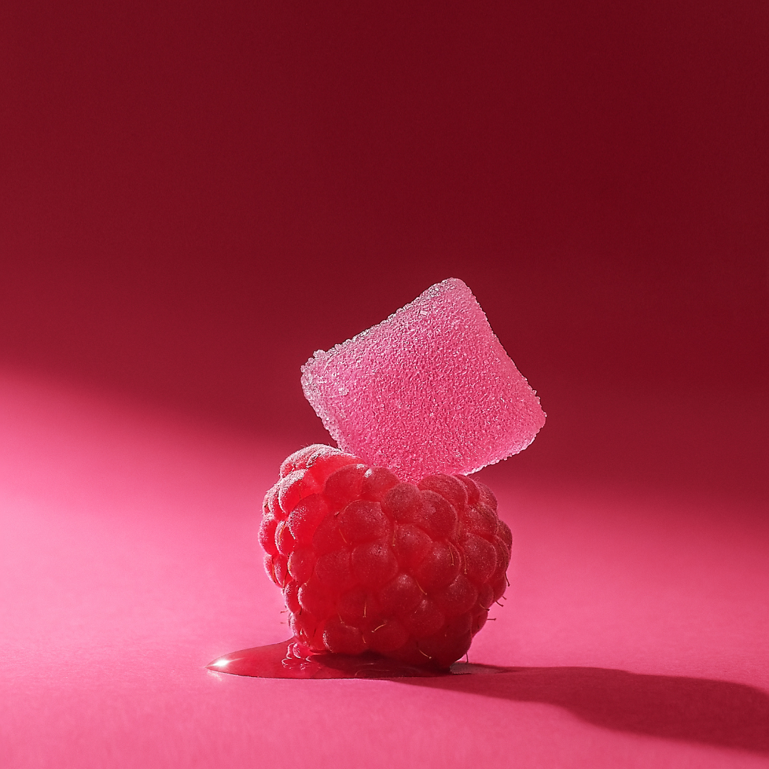 a raspberry gummy on top of a raspberry