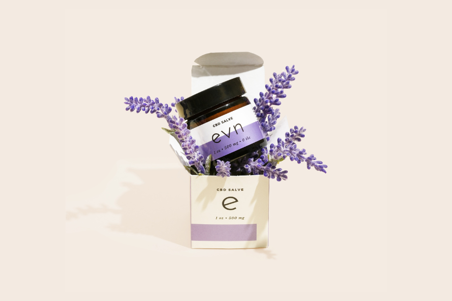 a jar of lavender salve with lavender flowers next to it