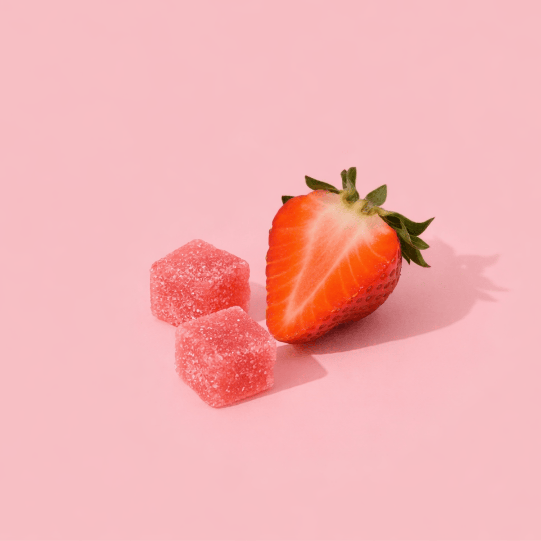 half cut strawberry next to gummies