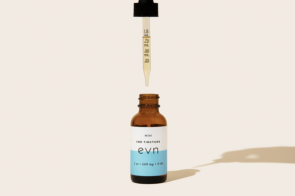 Jar of Evn Mint CBD Oil with dropper hovering over it.