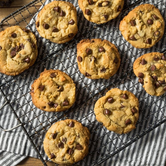 chocolate chip cookies cooling on a rack with a striped cloth underneath it