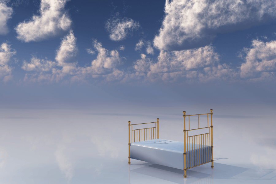 a bed with clouds in the background