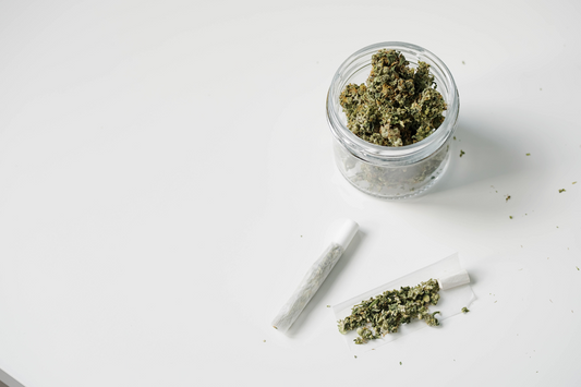 a jar of cannabis next to a joint