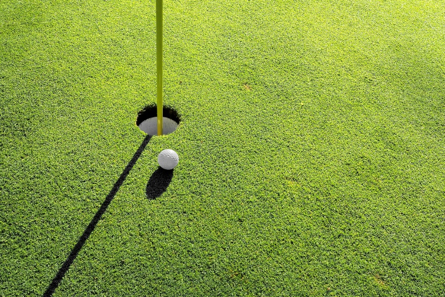 a golf ball next to a golf hole