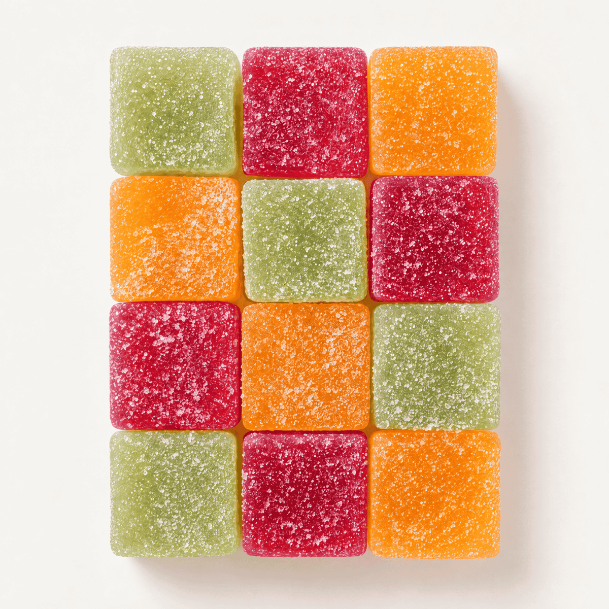 A 3x4 grid of square, sugar-coated gummy candies in three colors: light green, bright red, and orange, arranged neatly on a clean white background.