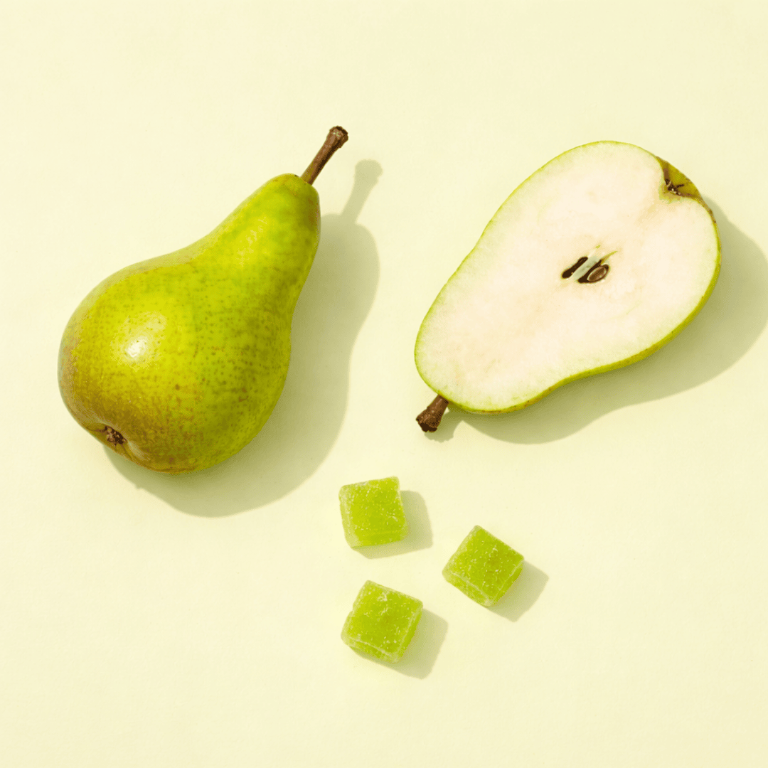 three pear gummies next to pears